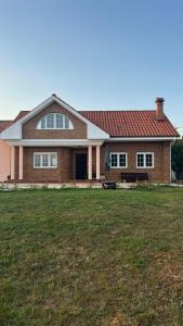 a house with a grass field in front of it at Finca la Tierruca de Cudon in Cudón