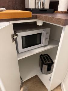 a microwave oven on a shelf in a kitchen at Apartment in Berlin-Köpenick in Berlin +17 photos