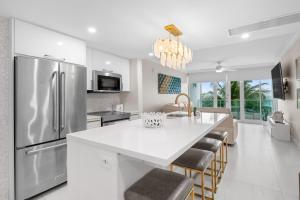 a kitchen with a stainless steel refrigerator and a table at Designer Oceanview Penthouse & Pool - Condado in San Juan
