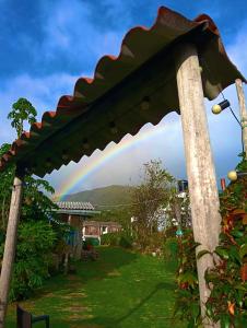 a rainbow in the sky over a garden at Bahareque hospedaje in Monguí