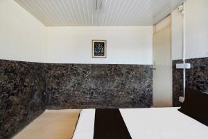 a bedroom with a bed with a black wall at hotel O snow breeze adventures in Dhanaulti