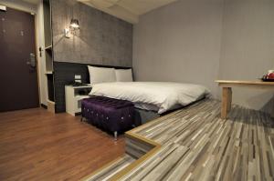 Schlafzimmer mit einem Bett, einem Tisch und einer Bank in der Unterkunft 泊居旅店 Oursinn Hotel in Taipeh