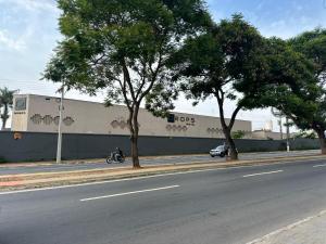 a person riding a motorcycle in front of a building at Drops Motel Goiânia in Goiânia