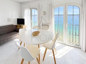a living room with a table and chairs and the ocean at Xilgar Apto Proa 2d encima de la playa in Raxó