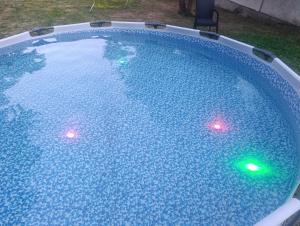 a swimming pool with two lights in the water at Casa & Spa Medison in Zrenjanin