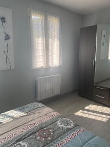 a bedroom with a bed and a tv and window at Gite du Lac in Lourdes