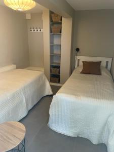 a bedroom with two beds and a table at Tallgatan Garden in Fjällbacka