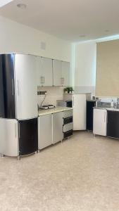 a large kitchen with white cabinets and black appliances at شقه فندقه in Hail
