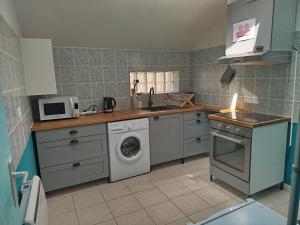 a kitchen with a sink and a washing machine at L'Érable du perche in Tourouvre +1 photo