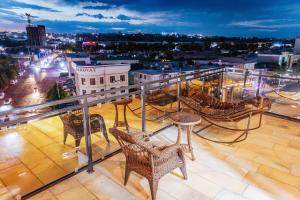 a balcony with chairs and tables and a city at Leore Hotel in Namangan