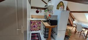 a kitchen with a refrigerator with its door open at Hébergement VIGNES ET RIVIERES in Écuelles +1 photo