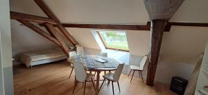 a dining room with a table and chairs and a window at Hébergement VIGNES ET RIVIERES in Écuelles
