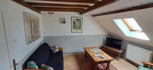 a living room with a couch and a tv at Hébergement VIGNES ET RIVIERES in Écuelles