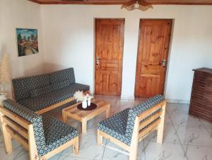 a living room with two benches and a table at Les Jardins d'Areca in Antsirabe