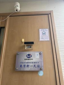 a sign is on the door of a building at Tokyo Shinichi House A in Tokyo