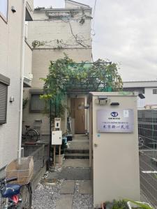 a house with a small refrigerator in front of it at Tokyo Shinichi House A in Tokyo