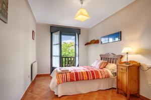 a bedroom with a bed and a window at Chalet Picu Fontanielles en Colunga in Colunga