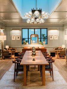 a dining room with a table and a chandelier at Clayton Hotel & Members Club - Cherry Creek, Denver in Denver