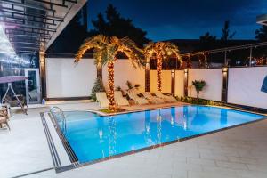 a swimming pool with palm trees on a building at Leore Hotel in Namangan