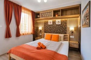 a bedroom with a large bed with orange pillows on it at Soline Bay Seashore Residence in Soline