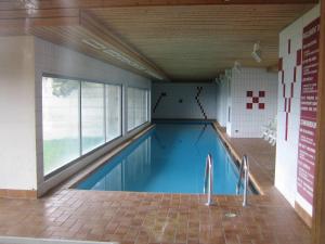 a swimming pool in a building with a large window at Immeuble Belvédère in Les Collons