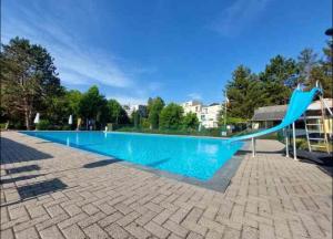 a large swimming pool with a blue slide at Studio Cosy 2 in Han-sur-Lesse