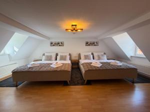 two beds sitting in a attic bedroom with at MARKINA - Ferienwohnung - Kiliani I in Mühlhausen