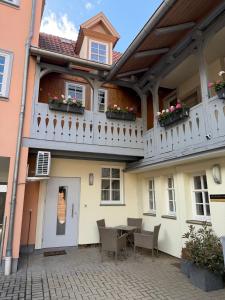 a building with a balcony with a table and chairs at MARKINA - Ferienwohnung - Kiliani I in Mühlhausen