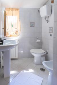 a white bathroom with a sink and a toilet at Residence Da Carmelo in Palinuro