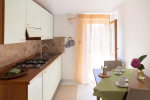 a kitchen with white cabinets and a table and a window at Residence Da Carmelo in Palinuro