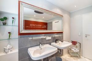 a bathroom with two sinks and a large mirror at Apartmenthaus Baden-Chalet in Bühl