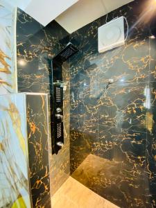 a bathroom with a black and gold marble shower stall at Madushanka Resort in Ella +105 photos