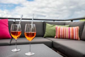 two glasses of wine sitting on a table next to a couch at Apartmenthaus Baden-Chalet in Bühl +24 photos