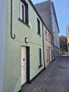 a green building with a door on a street at 3 Eyre Square Lane in Galway