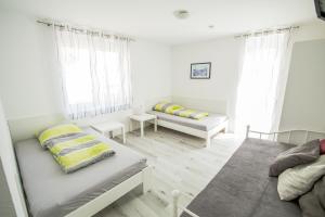 a white room with two beds and a couch at Murthum Apartments in Leinfelden-Echterdingen
