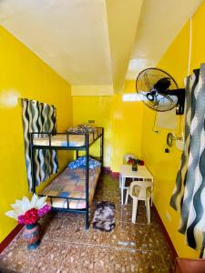 a room with two bunk beds and a yellow wall at Polangui Transient Room A Simple Transient House in Polangui