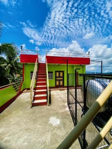 a small green and red house with a staircase at Polangui Transient Room A Simple Transient House in Polangui