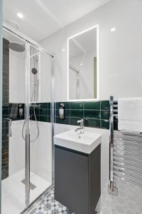 a bathroom with a sink and a shower at Upper Victoria in London