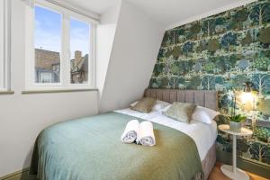 a bedroom with a bed with towels on it at Upper Victoria in London