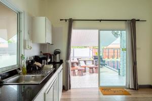 a kitchen with a sliding glass door to a patio at Blue Lake Residences - Pattaya in Nong Prue