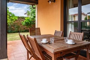 a wooden table and chairs on a patio at Chalet Picu Fontanielles en Colunga in Colunga