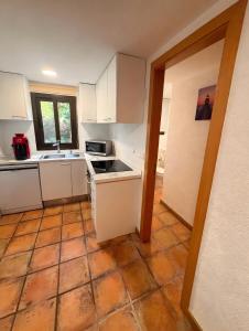 a kitchen with white cabinets and a tile floor at Ca la Selma in Aiguamurcia