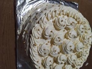 a cake with white frosting on top of tin foil at Debi in Lentekhi