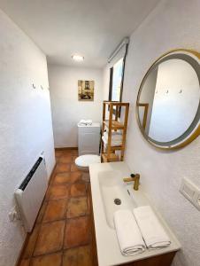 a bathroom with a sink and a mirror and a toilet at Ca la Selma in Aiguamurcia +3 photos
