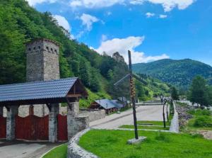 a church with a cross in front of a mountain at Debi in Lentekhi