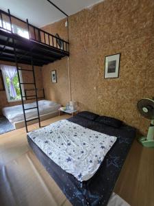 a bedroom with a bed and a loft bed at แม่ไพโฮมสเตย์ ล่องแพกอนโดล่า in Ban Racha Tai