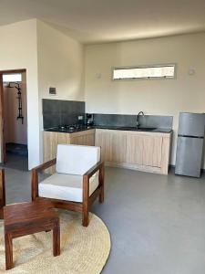 a kitchen with a chair and a table and a refrigerator at Villa Soa in Nosy Be