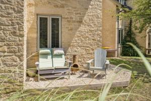 two lawn chairs sitting in front of a building at Moorhens in Somerford Keynes