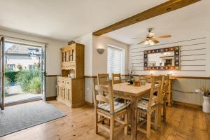 a dining room with a wooden table and chairs at Moorhens in Somerford Keynes