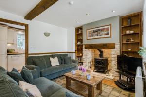 a living room with a couch and a fireplace at Moorhens in Somerford Keynes +18 photos